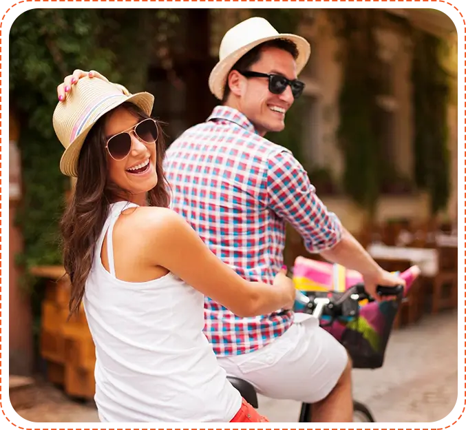 A man and woman riding bikes down the street.