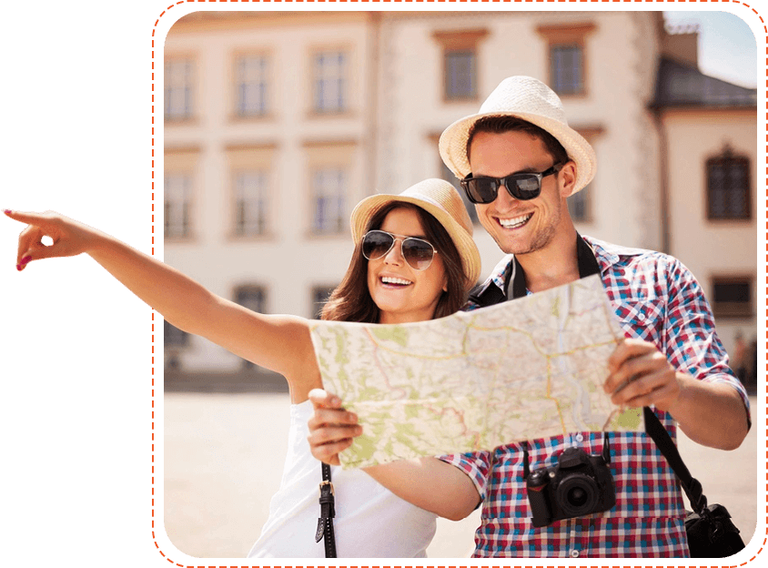 A man and woman holding a map in front of buildings.